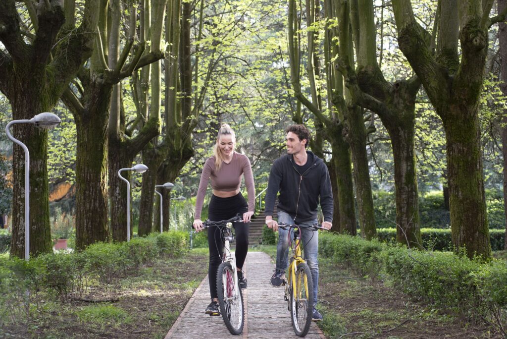 giovane coppia in bicicletta nel parco delle terme di monticelli